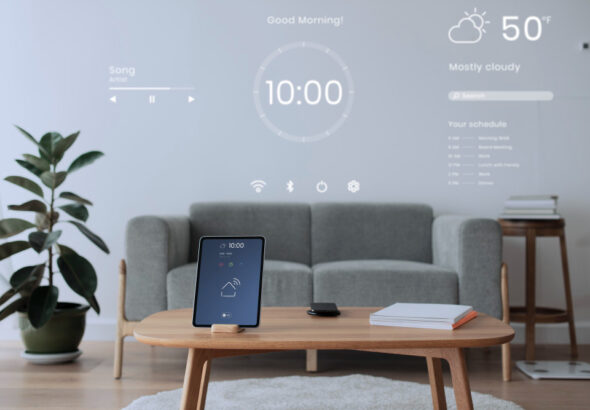Modern smart home living room with a wall-projected digital dashboard showing weather, schedule, music controls, and clock, alongside a smart sensor tablet on a coffee table.